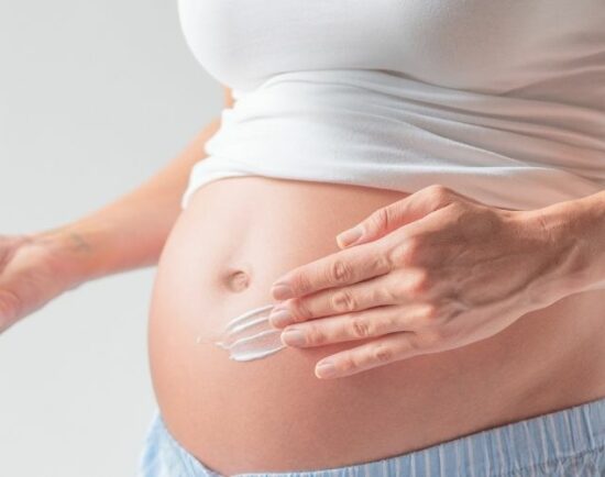 Woman cares for her stretch marks on belly