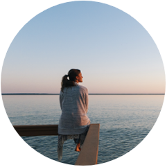 Frau, die am Meer in die Ferne blickt