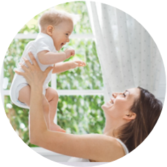 Mama, die ihr Baby in die Luft hebt