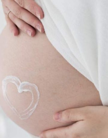 Frau mit Herz aus Pflege auf dem Bauch